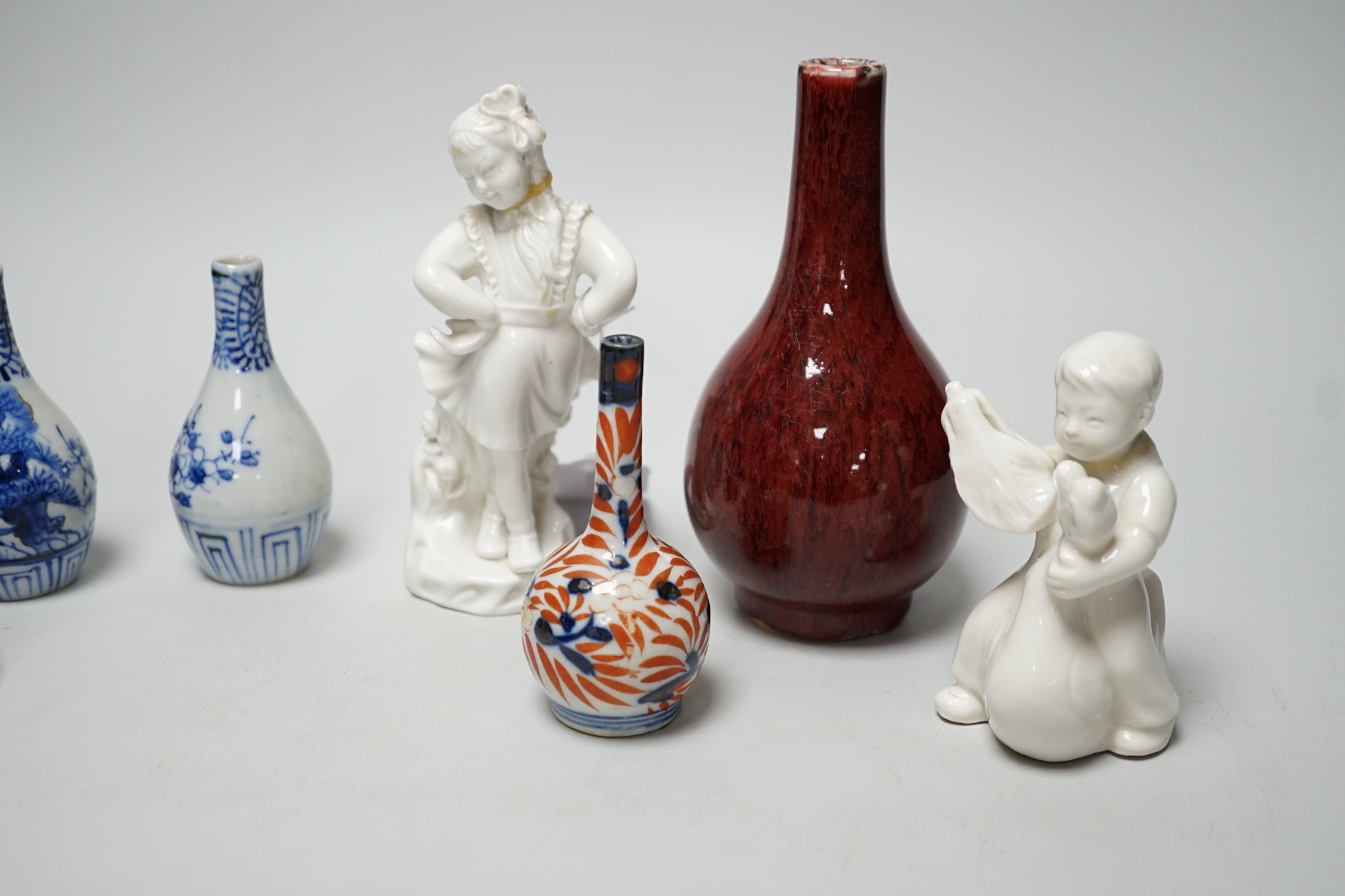 A Chinese sang de boeuf bottle neck vase, together with four Chinese miniature vases, three Chinese figures and a Chinese tea bowl, tallest 15cm